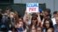 FILE - Females chant for equal pay for women as they wait for the United States women's national soccer team in New York City, July 10, 2019. 