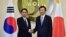 South Korean Foreign Minister Yun Byung-Se, right, and his Japanese counterpart Fumio Kishida pose for a photo at the start of their meeting at Foreign Ministry in Seoul, Dec. 28, 2015. 