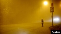 A bystander watches as ash falls from Calbuco volcano in the Patagonian Argentine area of San Marin de Los Andes, April 22, 2015. 