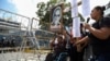 Un manifestante en silla de ruedas levanta una imagen del asesinado Monseñor Oscar Arnulfo Romero (1917-1980), a quien los pobres consideran su defensor, durante una protesta frente a la Asamblea Legislativa en San Salvador, El Salvador, el martes 16 de agosto de 2022.