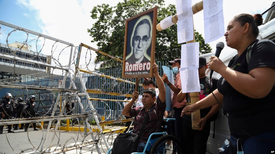Un manifestante en silla de ruedas levanta una imagen del asesinado Monseñor Oscar Arnulfo Romero (1917-1980), a quien los pobres consideran su defensor, durante una protesta frente a la Asamblea Legislativa en San Salvador, El Salvador, el martes 16 de agosto de 2022.