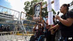 Un manifestante en silla de ruedas levanta una imagen del asesinado Monseñor Oscar Arnulfo Romero (1917-1980), a quien los pobres consideran su defensor, durante una protesta frente a la Asamblea Legislativa en San Salvador, El Salvador, el martes 16 de agosto de 2022.