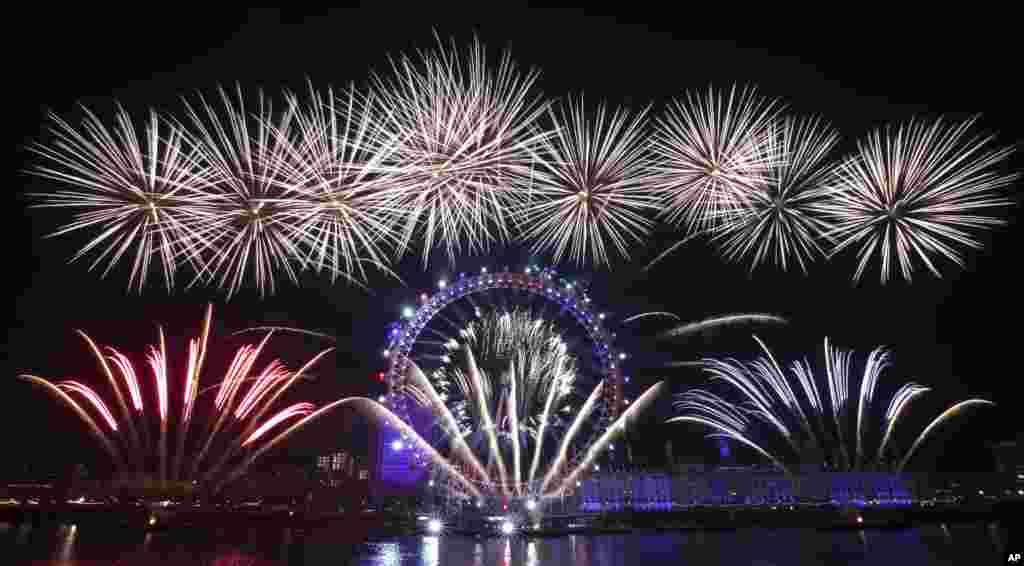 Fireworks explode over the London Eye Ferris wheel by the River Thames to mark the start of the new year.