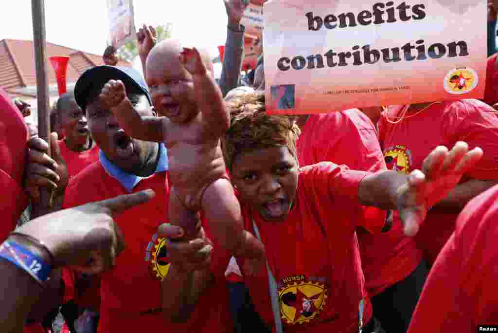 A member of the National Union of Metalworkers of South Africa (NUMSA) holds a baby doll as strikers march in Cape Town, Sept. 9, 2013.