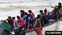 Migrantes venezolanos, que fueron deportados, llegan a la costa en la playa Los Iros después de su regreso a la isla, en Erin, Trinidad y Tobago, el 24 de noviembre de 2020.