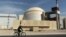 FILE - A worker rides in front of the reactor building of the Bushehr nuclear power plant, just outside Bushehr, Oct. 26, 2010. 