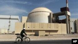 FILE - A worker rides in front of the reactor building of the Bushehr nuclear power plant, just outside Bushehr, Oct. 26, 2010. 