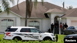 Polisi berjaga-jaga di depan salah satu rumah yang diduga terkait dengan penembak Orlando di Port St. Lucie, Florida (12/6). (Reuters/Joe Skipper)