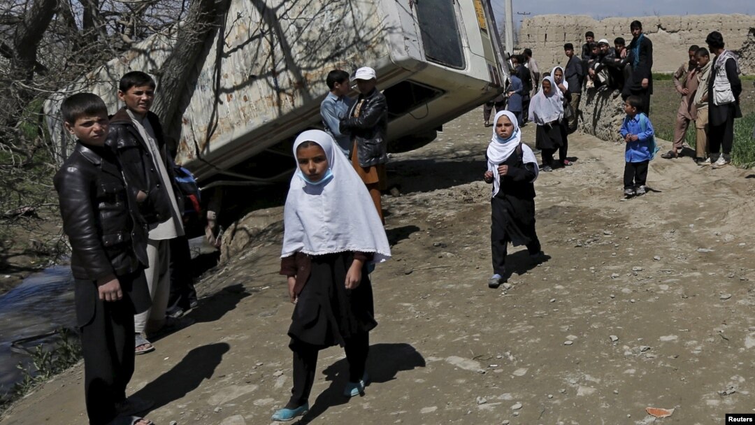 Bagrom tumanida portlatilgan avtobus oldidan o'tib ketayotgan bolalar, 11-aprel, Kobul, Afg'oniston