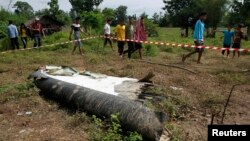 17일 라오스 항공기 추락 사고 현장에서 주민들이 항공기 잔해를 지켜보고 있다.