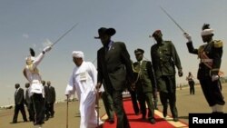 Les présidents Salva Kiir (au c.) et Omar el-Béchir (en blanc) après une conférence de presse à Khartoum en octobre 2011