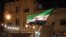 A handout picture released by the Syrian opposition's Shaam News Network shows a Syrian protester waving a pre-Baath Syrian flag during an anti-regime demonstration in Dael in the southern Daraa province late on April 12, 2012.