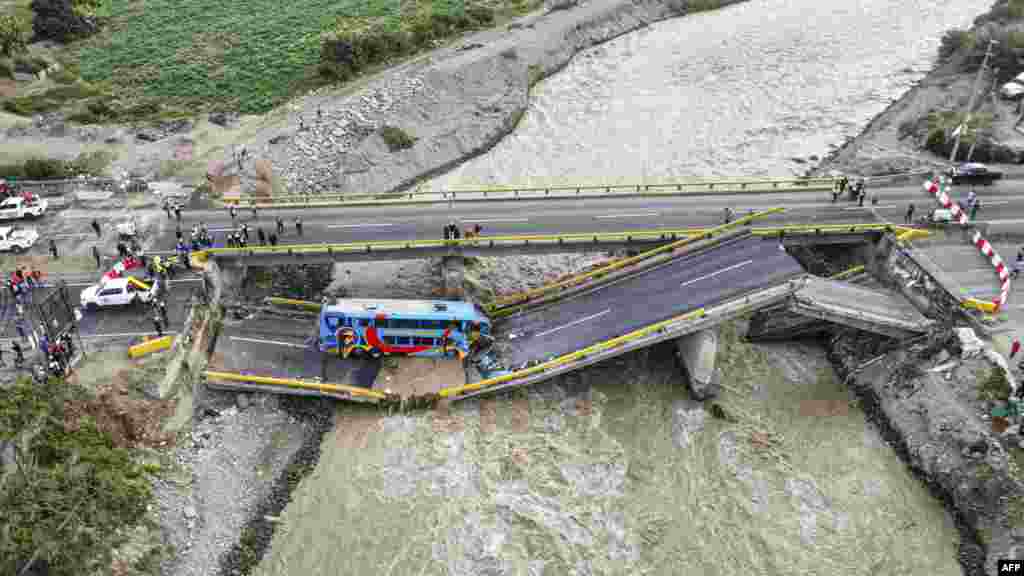 Rescuers work at the scene after a passenger bus fell into a river, killing at least two people, when a bridge collapsed in Chancay, north of Lima.