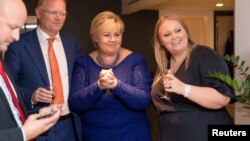 Norway's Prime Minister Erna Solberg, her daughter Ingrid Solberg Finnes and Sgbjorn Aanes, Solberg's adviser react on the results of Solberg's Conservative party Hoyre in Oslo, Norway, Sept. 11, 2017. (NTB Scanpix/Hans Kristian Thorbjoernsen/Hoyre via Reuters)
