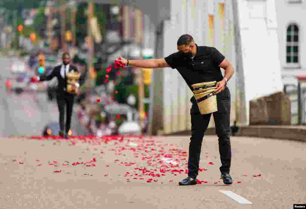 Personas de la funeraria Willie Watkins esparcieron p&#233;talos de rosas que representan la sangre derramada el Domingo Sangriento en el puente Edmund Pettus, antes del inicio de la procesi&#243;n del legislador estadounidense, el domingo 26 de julio. en Selma.