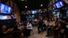 FILE - People watch TV screens showing a debate between Democratic presidential nominee Vice President Kamala Harris, right on screen, and Republican presidential nominee former President Donald Trump, at Sports Grill Kendall, Sept. 10, 2024, in Miami, Florida. 