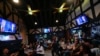 FILE - People watch TV screens showing a debate between Democratic presidential nominee Vice President Kamala Harris, right on screen, and Republican presidential nominee former President Donald Trump, at Sports Grill Kendall, Sept. 10, 2024, in Miami, Florida. 