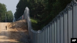 FILE - A Polish border guard patrols the area of a metal wall on the border between Poland and Belarus, near Kuznice, Poland, on June 30, 2022. Polish Prime Minister Donald Tusk on May 11, 2024, pledged to strengthen security along the border.