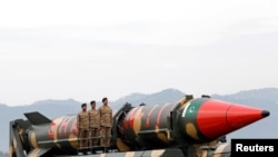 FILE - Pakistani military personnel stand beside a Shaheen III surface-to-surface ballistic missile during a Pakistan Day military parade in Islamabad, March 23, 2019. 