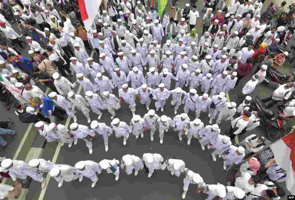 Kaum Muslimin Indonesia berbaris menuju istana presiden selama unjuk rasa menentang gubernur DKI Jakarta Basuki Tjahaja Purnama atas dugaan penghinaan di Jakarta.