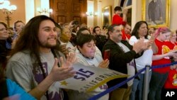 Supporters of a bill to raise California's minimum wage celebrate outside the state Senate Chamber after the measure was approved by the Senate, March 31, 2016, in Sacramento, California. (AP Photo/Rich Pedroncelli)