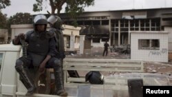 Des policiers burkinabè gardent le parlement incendié à Ouagadougou, au Burkina Faso, le 31 octobre 2014.