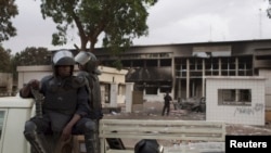 Des policiers en poste devant le Parlement incendié à Ougadougou, Burkina Faso, 31 octobre 2014. 