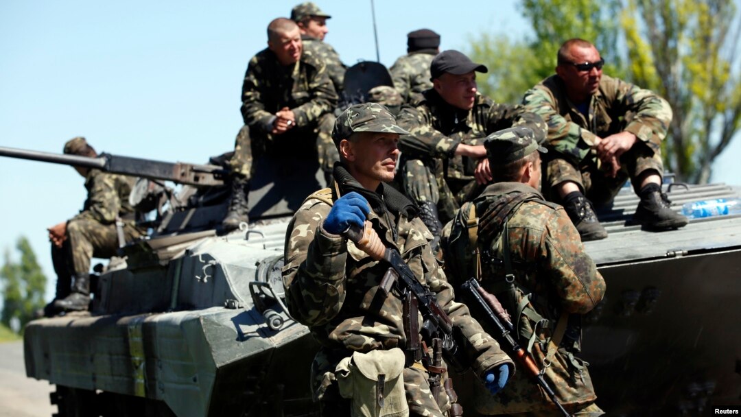 Ukrainian soldiers stand guard beside an armored personnel carrier at a checkpoint in Mariupol, eastern Ukraine, May 7, 2014. 