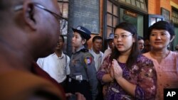 Mahasiswi Myanmar, Chaw Sandi Tun (25 tahun), berbicara dengan seorang pendeta Budha setelah sidang di pengadilan di kota Maubin, Myanmar, Selasa (24/11)