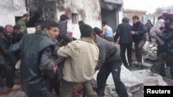 Местные жители эвакуируют погибших и раненых с места взрыва. Хальфая, Сирия. 23 декабря 2012 года