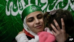 Aseel al-Titi, nosi Hamasovu traku za glavu, bivša palestinski zatvorenica koju su izraelske vlasti oslobodile, dočekuju prijatelji i članovi porodice u Balati, palestinskom izbjegličkom kampu u Nablusu, Zapadna obala, u petak, 24. novembra 2023.
