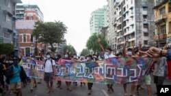 Anti-coup protesters hold a banner reading 'Mountains and the mainland are united' during a flash mob on June 3, 2021, in Yangon, Myanmar. 