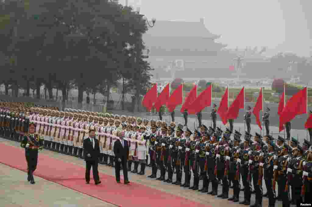 中国主席习近平和乌拉圭总统巴斯克斯在雾霾中的天安门广场上的欢迎仪式中检阅仪仗队（2016年10月18日）