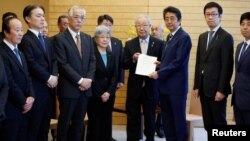 Perdana Menteri Jepang Shinzo Abe (tiga dari kanan) menerima petisi dari Shigeo Iizuka (tengah), pemimpin sekelompok keluarga Jepang yang diculik Korea Utara, di dampingi Sakie Yokota (sebelah kirinya) ibu dari Megumi Yokota, salah seorang korban penculikan Jepang dan anggotanya di kediaman resmi Abe di Tokyo, Jepang, 30 Maret 2018. (Foto: dok).