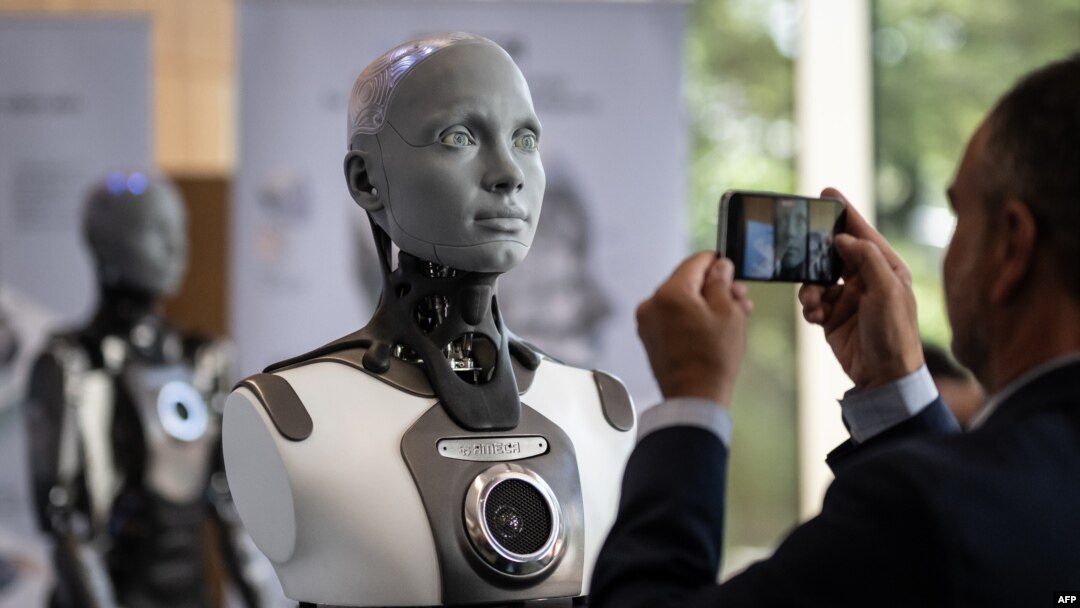 Posetilac slika humanoidnog robota Amiku na samitu o pozitivnoj upotrebi veštačke inteligencije u Ženevi, 6. jula 2023. (Foto: AFP/Fabrice Coffrini)