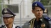 Cambodian police and soldiers look on outside during a hearing at the U.N.-back genocide tribunal.