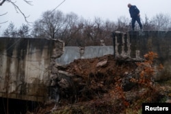 Seorang petugas polisi berpatroli di dekat kanal yang rusak di Kosovo utara untuk memasok air ke dua pembangkit listrik tenaga batu bara yang menghasilkan hampir seluruh listrik di negara itu, di Varage, dekat Zubin Potok, Kosovo, 30 November 2024. (Foto: Valdrin Xhemaj/Reuters)