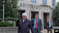 FILE - Greg Craig, former White House counsel to former President Barack Obama, left, leaves federal court in Washington, April 12, 2019.