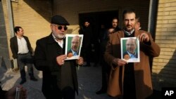 FILE - Supporters of Mohammad Bagher Qalibaf, a leading hard-line parliamentary election candidate from Tehran constituency, hold posters of Qalibaf, at a campaign meeting in Tehran, Iran, Feb. 18, 2020. 