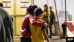 Foto divulgada por las Fuerzas de Defensa de Israel muestran a un niño israelí liberado por Hamás al reunirse con su madre el 28 de noviembre de 2023.