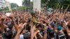 Los manifestantes llevan a un miembro del Ejército sobre sus hombros mientras celebran la renuncia de la Primera Ministra Sheikh Hasina, en Dhaka, Bangladesh, el lunes 5 de agosto de 2024.