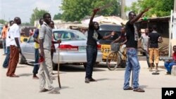 'Yan bangar Fararen Hulan JTF suna anfani ne da kulake da sanduna da makaman da aka sarafa cikin gida suna sintiri a kan titunan Maiduguri, Najerya.