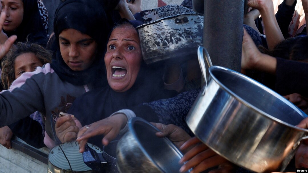 Palestinians gather to receive food cooked by a charity kitchen, amid a hunger crisis as the Israel-Gaza conflict continues in Khan Younis in the southern Gaza Strip, Dec. 4, 2024.