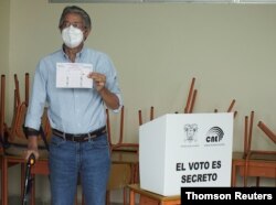 El candidato presidencial Guillermo Lasso muestra su papeleta antes de emitir su voto en la segunda vuelta de las elecciones presidenciales en un colegio electoral, en Guayaquil, Ecuador, el 11 de abril de 2021.