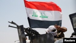 Seorang anggota pasukan keamanan Irak mengacungkan dua jarinya di dekat kota Fallujah, Irak (31/5),