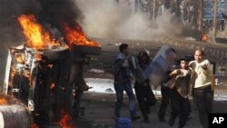 Police and unidentified people are seen in the streets during a demonstration in Suez, Egypt, Jan 28, 2011