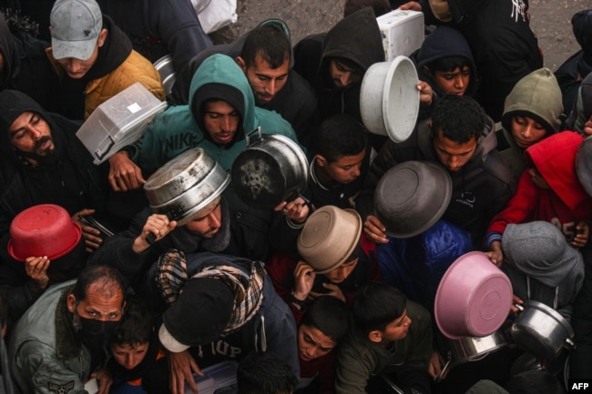 Palestinians receive food rations at a donation point at a camp for internally displaced people in Rafah, Gaza Strip, on Feb. 2, 2024.