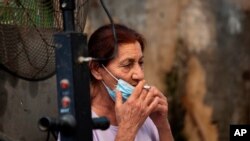 Una mujer israelí baja su mascarilla para fumar un cigarrillo en un mercado del pueblo de Rambla, cerca de Tel Aviv, el pasado 15 de julio.