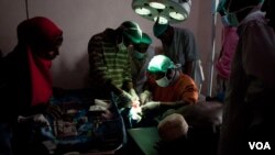 Surgeons-in-training close an incision in a new operating theater, Ras Kamboni, Somalia, July 6, 2012. (VOA - R. Gogineni) 