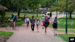 FILE - Students walk to and from classes on the Indiana University campus, Oct. 14, 2021, in Bloomington, Indiana. 